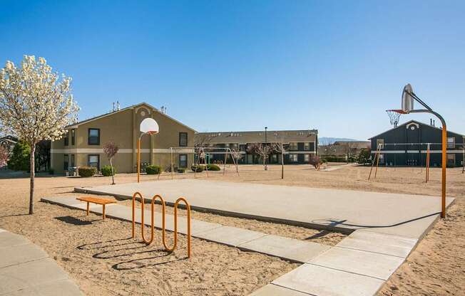 A basketball court with a basketball hoop and a building in the background.