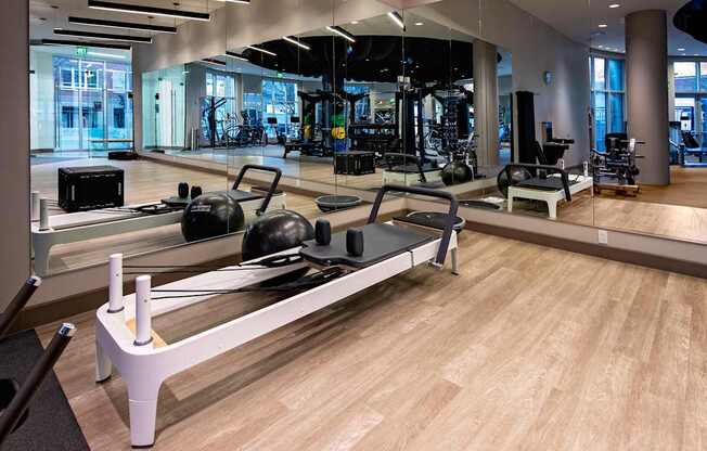 A gym with a rowing machine in the foreground.