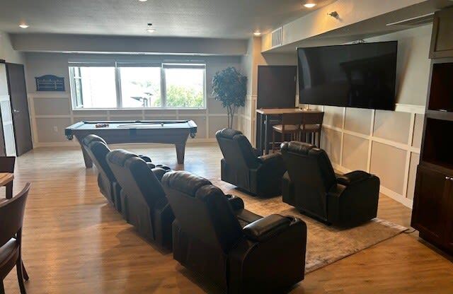 a living room with a pool table and a tv