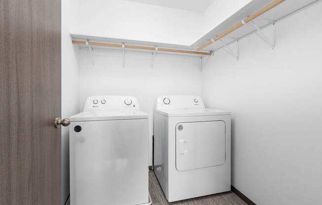Two white washing machines in a laundry room.