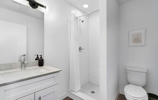 A white bathroom with a walk in shower.