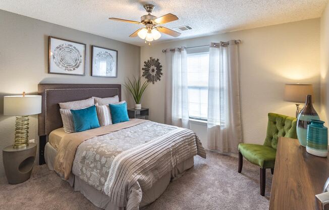 furnished apartment bedroom with carpeting and a ceiling fan