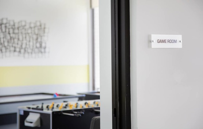 A foosball table is in a room with a sign that says Game Room.