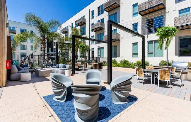 A modern outdoor seating area with blue and white chairs.