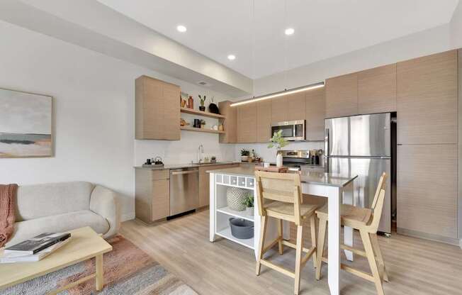 A modern kitchen with wooden chairs and a dining table.
