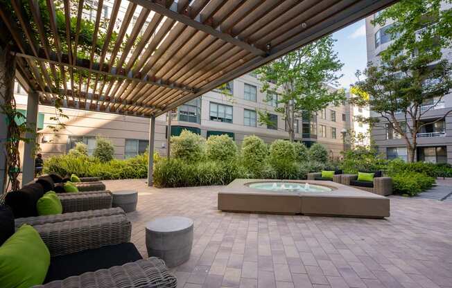 A patio with a fountain and a pergola.