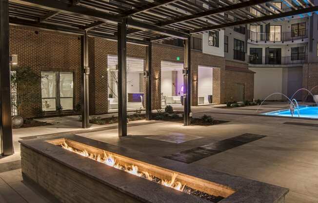 a fire pit in the middle of an apartment complex at night