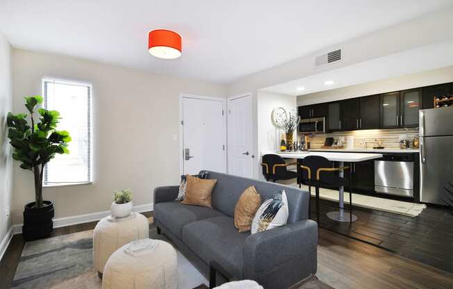 a living room with a couch in front of a kitchen