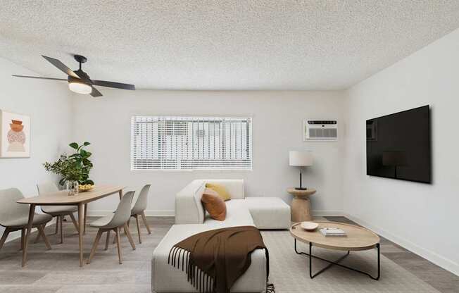A living room with a couch, chairs, and a ceiling fan.