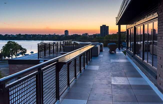 A balcony overlooks a body of water with a sunset in the background.