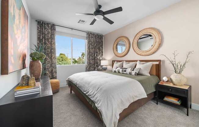 A bedroom with a bed, nightstand, and a ceiling fan.