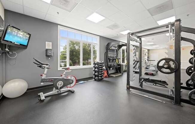 a gym with weights and other exercise equipment and a window