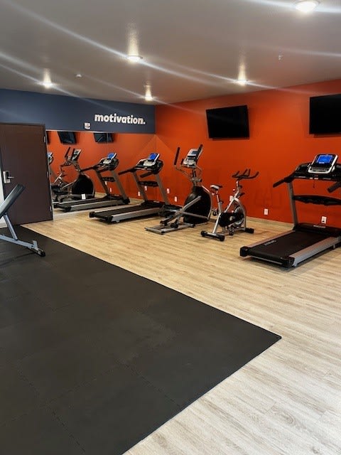 a gym with a bunch of exercise equipment on the floor