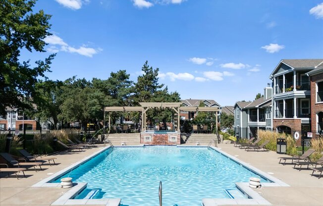 A large swimming pool surrounded by trees and a building. at Somerset Oaks Apartment Homes, Kansas, 66062
