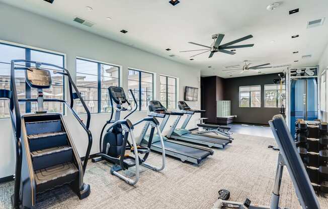 a gym with cardio equipment and windows in a building at Grandstone at Sunrise, Peoria