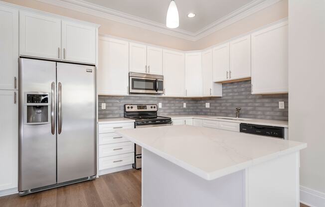 a kitchen with white cabinets and stainless steel appliances