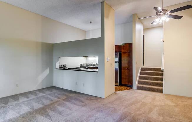 an empty living room with a ceiling fan at The Bluffs at Mountain Park, Lake Oswego, OR