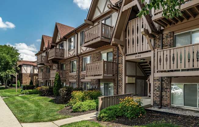 Apartment building with brown and beige exterior and a green lawn in front