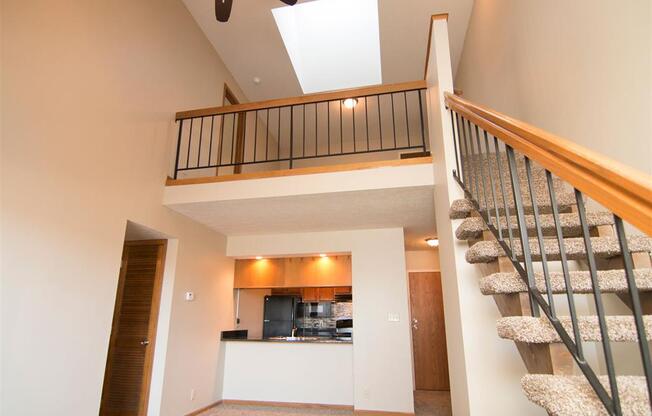 Kitchen and living room with view of stairs to the loft at Fountain Glen Apartments in Lincoln Nebraska