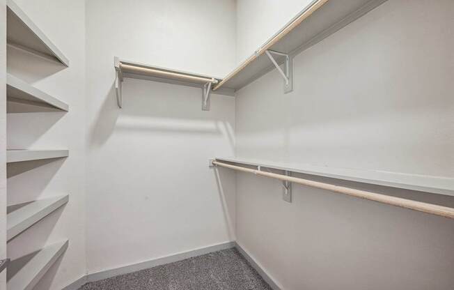 A white wall with a metal rail and a grey carpet.