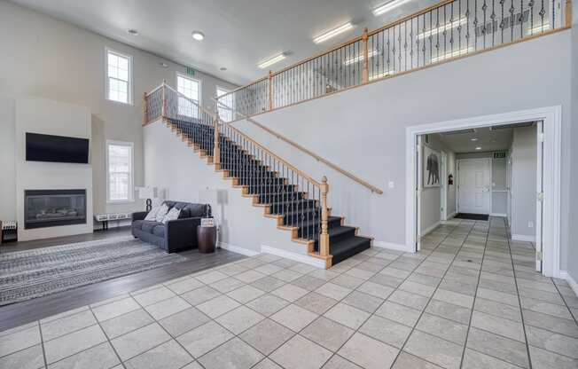 a spacious living room with a staircase leading up to the second floor