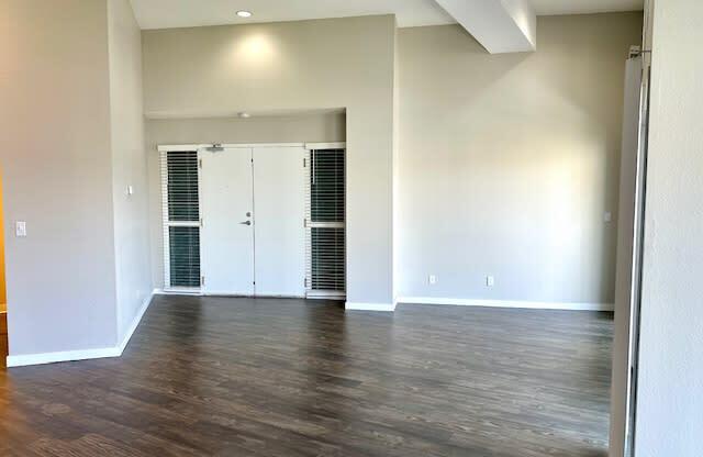 an empty living room with white walls and wood floors