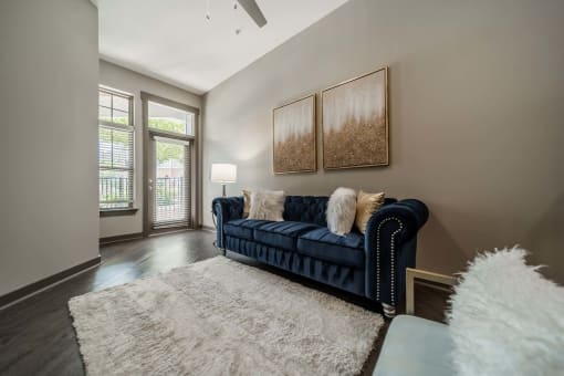 a living room with a blue couch and a rug