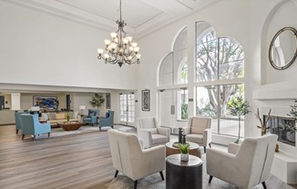 a living room with white furniture and large windows