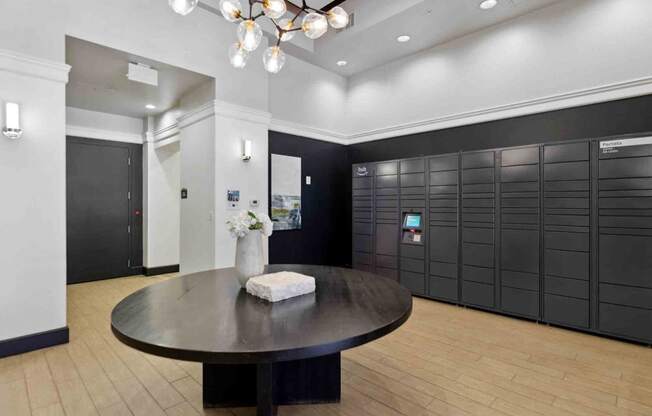 a large room with black lockers and a round table