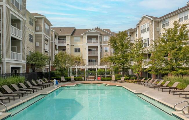 Central pool courtyard with surrounding lounge seating, landscaped greenery, and ample space for swimming, sunbathing, and enjoying time outdoors.