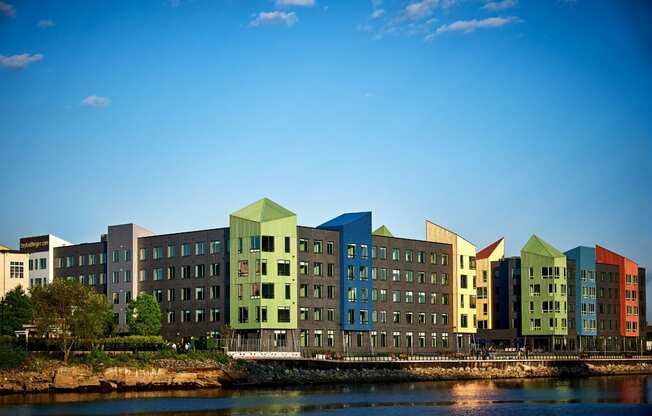 a row of buildings sitting next to a body of water at Dey & Bergen, Harrison, NJ