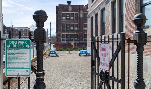 a dog park is behind a gate in front of a building