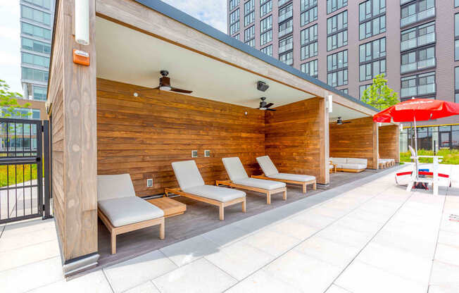 A wooden deck with lounge chairs and a red umbrella at Allied Harbor Point, Baltimore