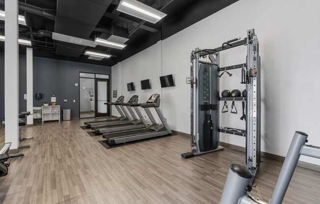 a fitness room with treadmills and weights in it