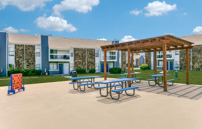a picnic area with picnic tables and benches in front of a building