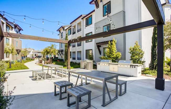 A patio with a table and chairs is surrounded by a white building.