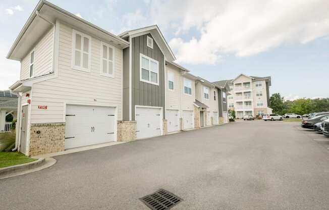 a row of white houses with cars parked in front of them