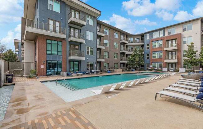 A large swimming pool in front of apartment buildings.