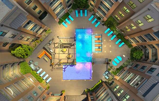 A swimming pool in the middle of a courtyard surrounded by buildings.
