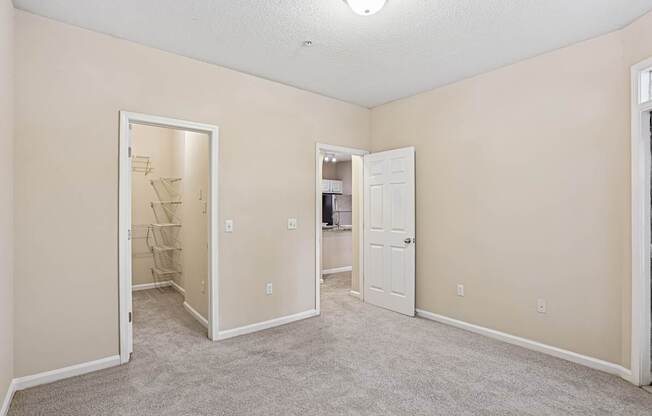 A room with a carpeted floor and two open doors.