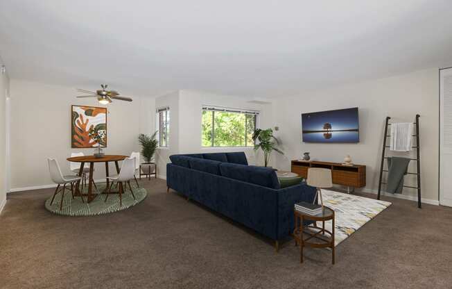 a living room with a blue couch and a table and chairs