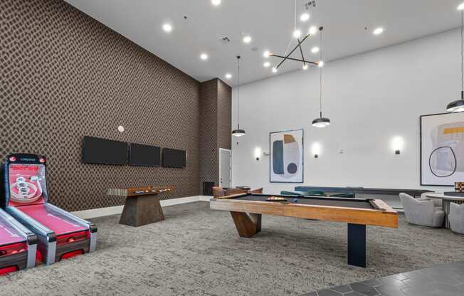 two pool tables in a room with televisions and other gaming equipment