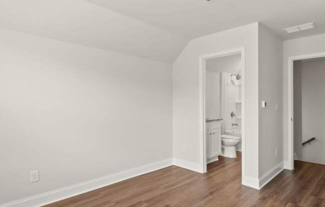 a living room with a hard wood floor and white walls