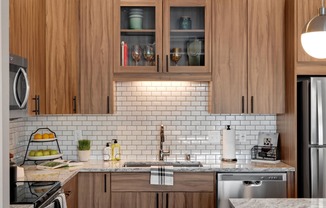 Wood cabinets and tile backsplash in Kitchen at Modern kitchen at Nuvelo at Parkside Apartments