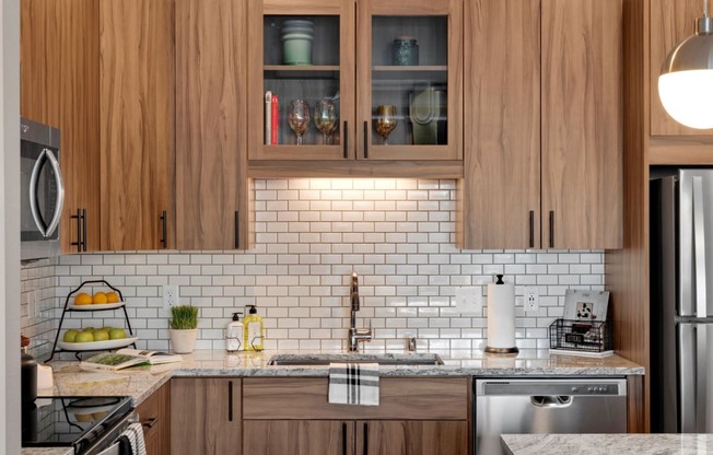 Wood cabinets and tile backsplash in Kitchen at Modern kitchen at Nuvelo at Parkside Apartments