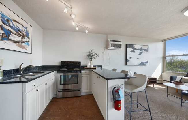 a kitchen with white cabinets and black counter tops and a table with chairs