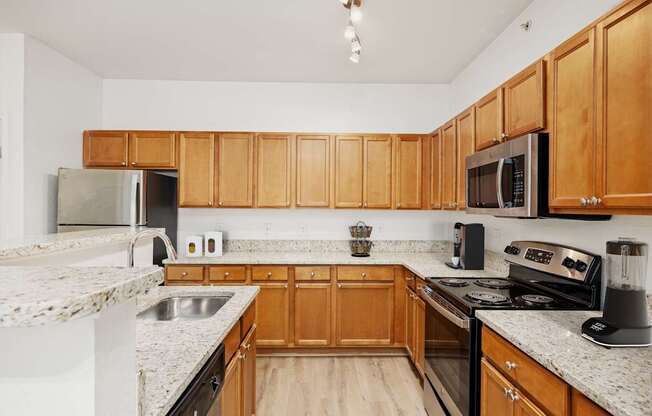 A kitchen with wooden cabinets and granite countertops.