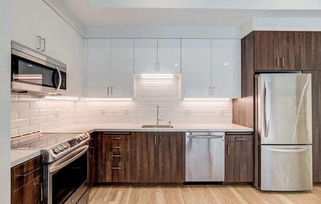 a modern kitchen with white cabinets and stainless steel appliances