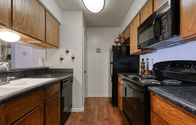 a kitchen with black appliances and wood cabinets