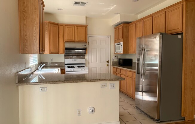 Two story home in gated community with community pool, featuring 4 bedrooms including one bedroom downstairs with a private bathroom! Home has a large great room with high ceilings that's visible from the second floor! Open kitchen with granite countertop